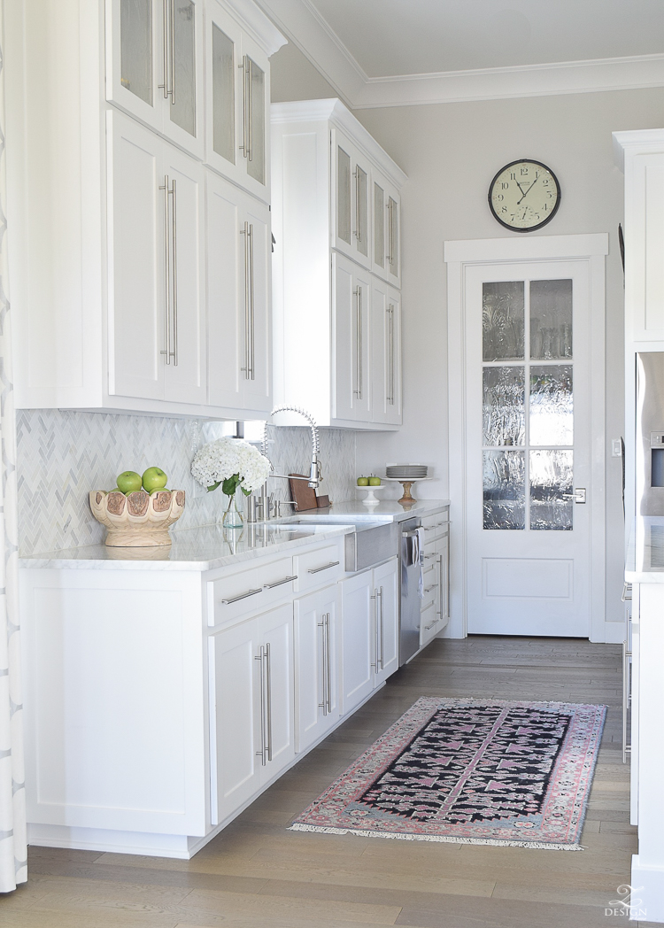 https://www.zdesignathome.com/wp-content/uploads/2017/08/10-simple-tips-for-styling-the-kitchen-counters-white-modern-farmhouse-kitchen-white-shaker-cabinets-white-carrar-marble-marble-counters-and-herringbone-backsplash-kitchen-countertop-decor-1.jpg
