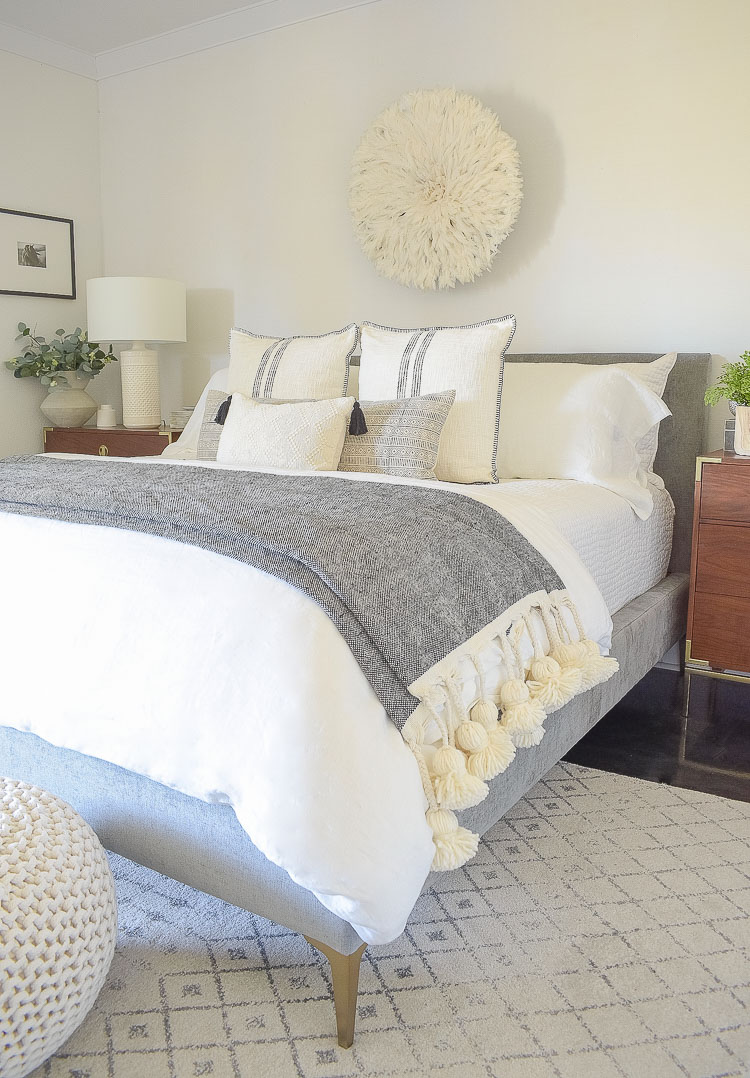 black and white spring bedroom tour - large tassel throw over end of bed 