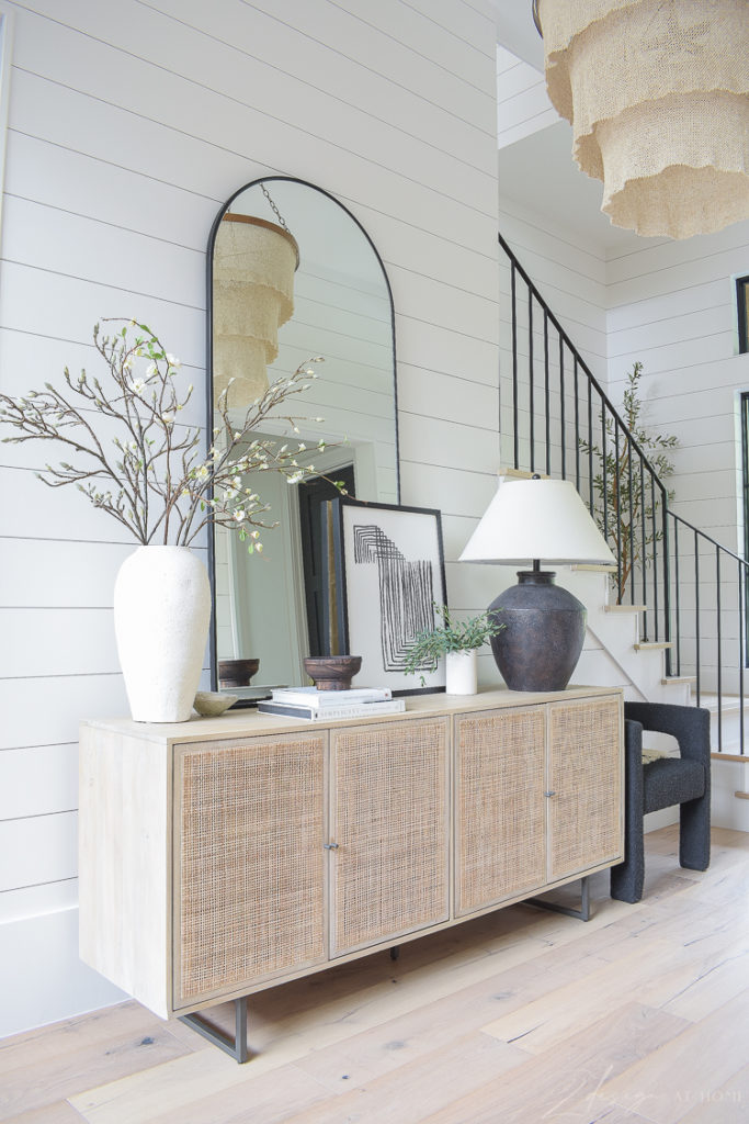 Cane console table in entry way with boho decor