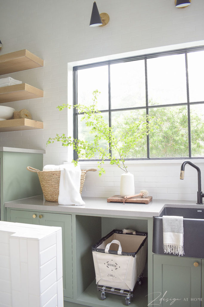 laundry room with gray green cabinets white tiled wall