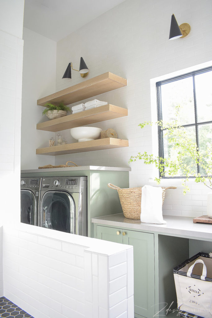 elegant laundry room with white oak shelves and builtin washer dryer