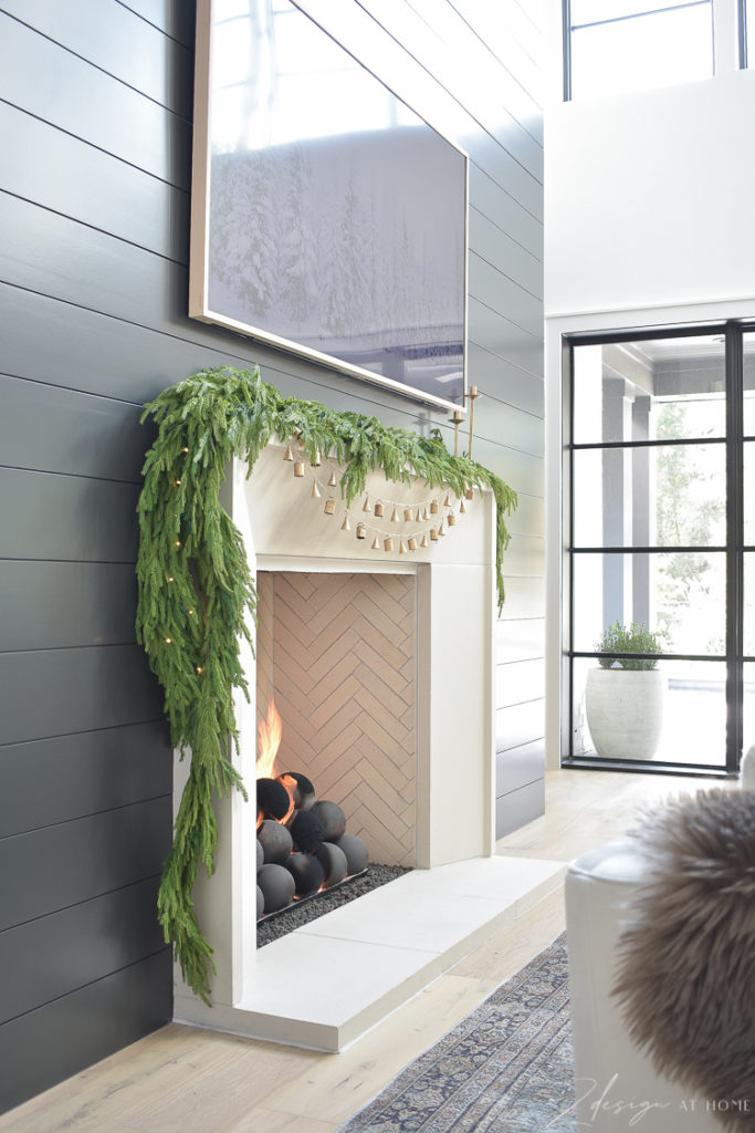 holiday mantle with decor and bell garland on capstone mantle black shiplap fireplace wall