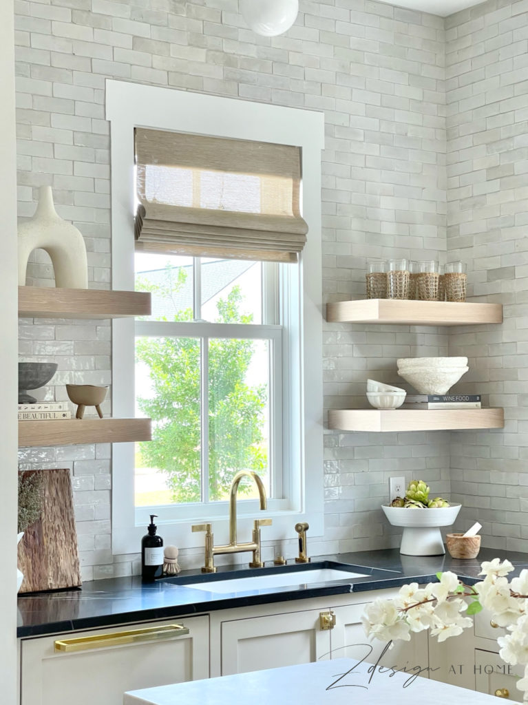 white oak open shelves in english inspired kitchen, black marble countertops and unlacquered brass fixtures