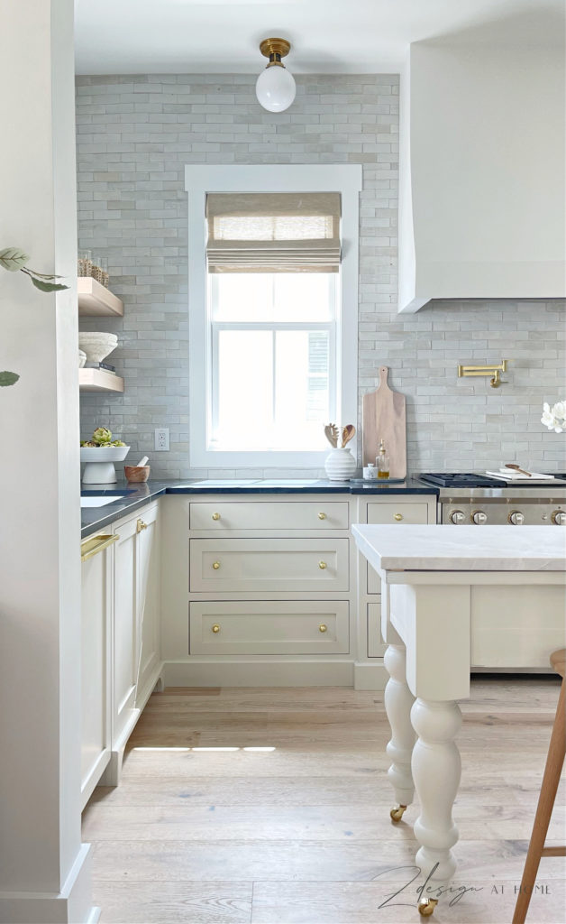 english inspired cottage kitchen with cream cabinets and zellige tile backsplash