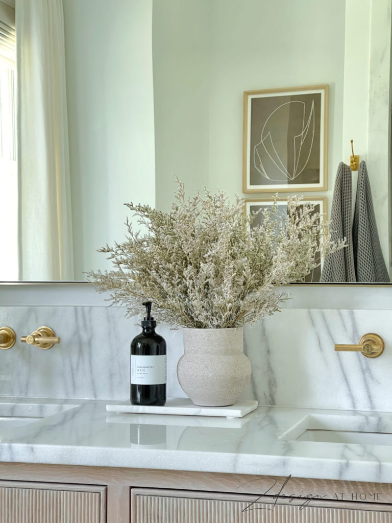 white oak vanity with fluted or reeded drawers, oversized brass mirror and unlaquered brass faucets