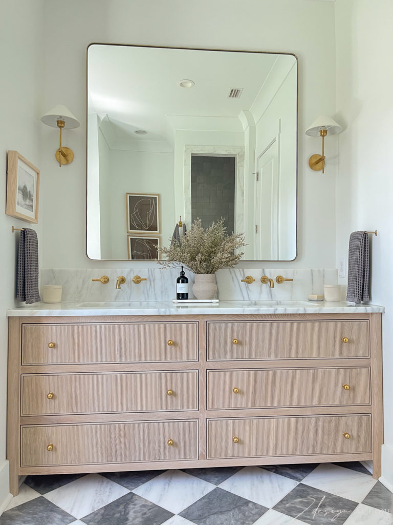 fluted white oak vanity with brass accents and marble countertops, checkered patterned marble floor