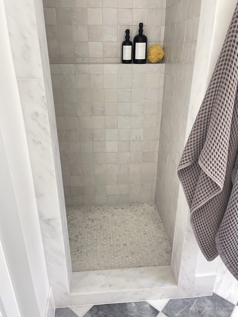 marble penny tile on shower floor and marble shower threshold