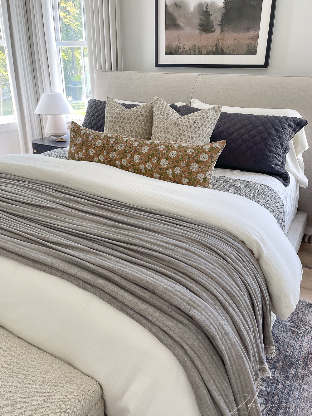 bed layers with decorative floral and block pillows 