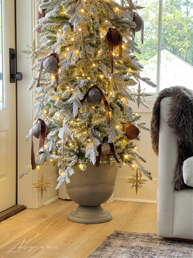 gray urn with small pencil slim christmas tree in it 