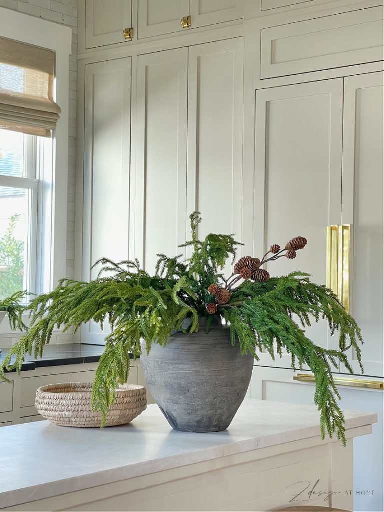 faux norfolk pine stems with pinecone stems in gray rustic vase 