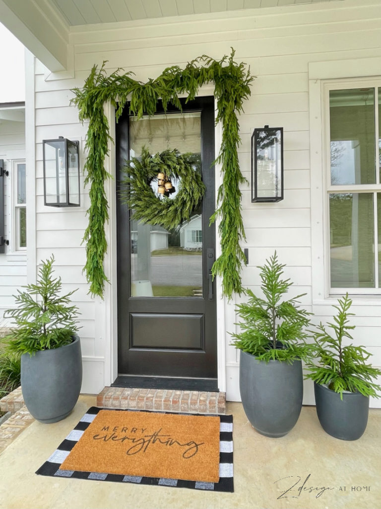 norfolk pine trees and garland around cottage door 