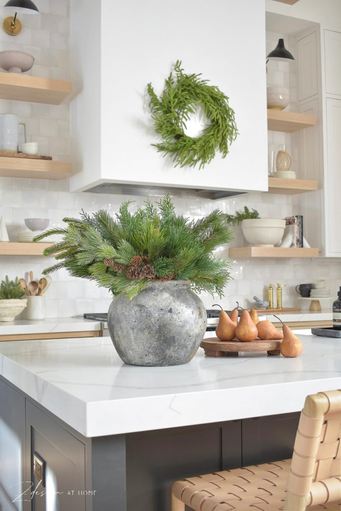 christmas spray in vase on white quartz and white oak kitchen